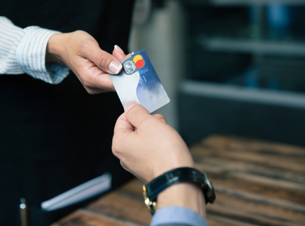 Closeup image of a man paying with credit card at the restaurant