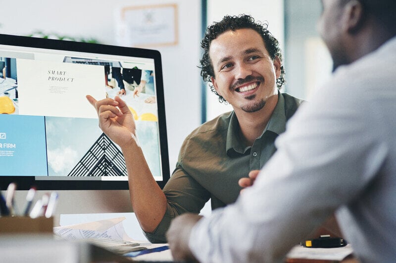 Man shows a mockup of the new website on a computer